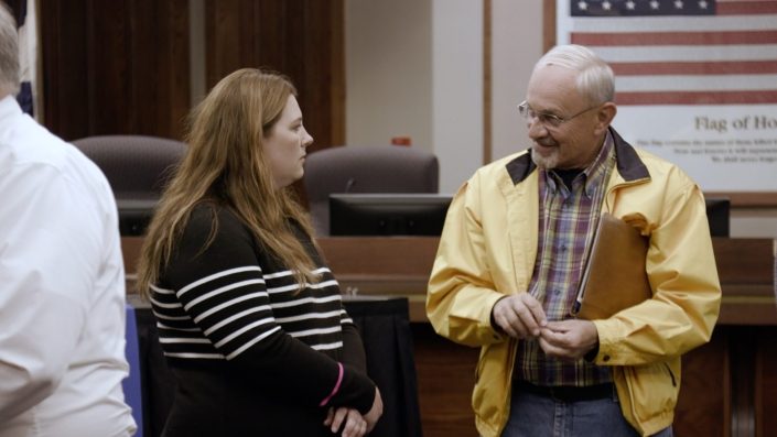 Brie Talking With Gentleman In Yellow Jacket