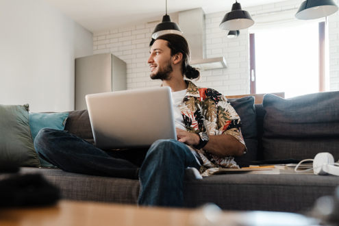Image of man sitting on couch with laptop