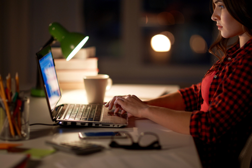 Image on woman using a laptop computer at night.