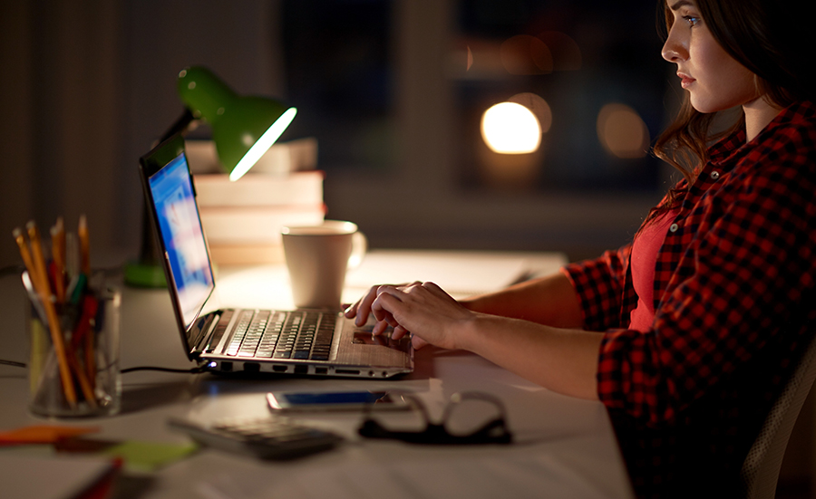 Image on woman using a laptop computer at night.