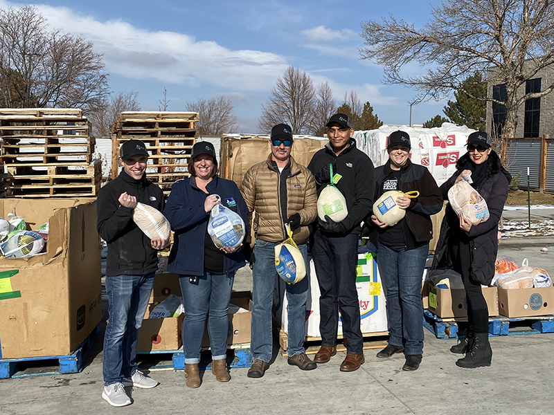 Image of Pulse team members holding turkeys during a Thanksgiving turkey drive event