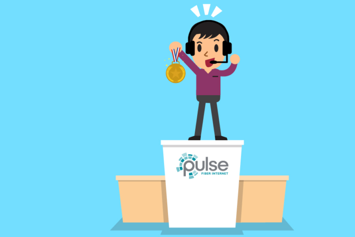 Image of a person holding a gold medal standing on top of a Pulse podium