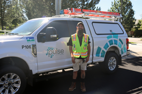 Photo of a Pulse technician standing next to a Pulse truck