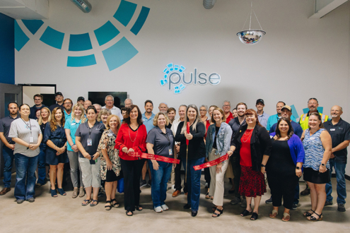 Photograph of group of people gathered for Pulse's ribbon cutting in September 2024.