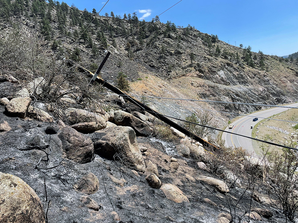 Photo of a utility pole downed due to the Alexander Mountain Fire