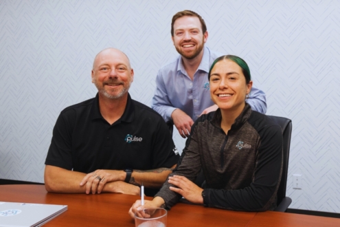 Photograph of 3 Pulse employees at a conference table